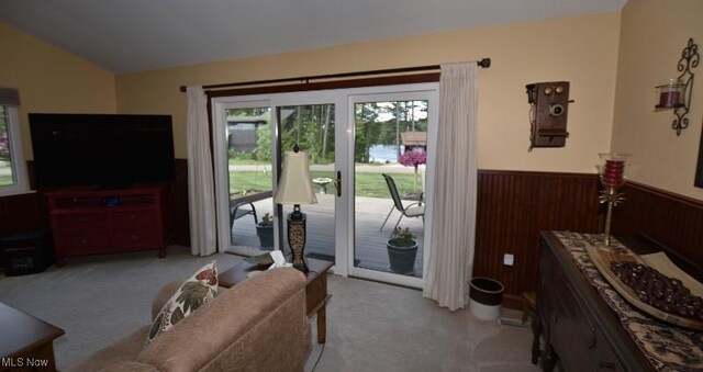 1208 Berwyn Dr SW, Sherrodsville, OH 44675 - living area featuring wainscoting, light carpet, healthy amount of natural light, vaulted ceiling, and wooden walls
