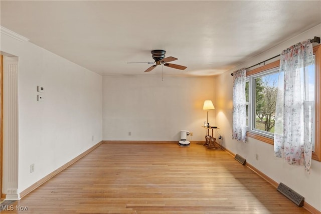 spare room featuring baseboards, visible vents, ceiling fan, and light wood-style flooring