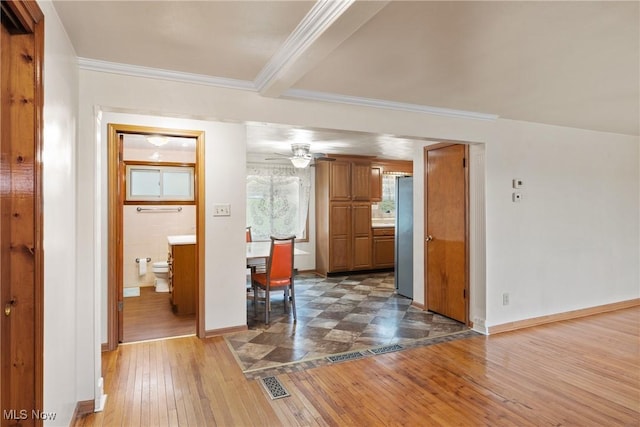 interior space featuring ornamental molding, visible vents, ceiling fan, and hardwood / wood-style flooring