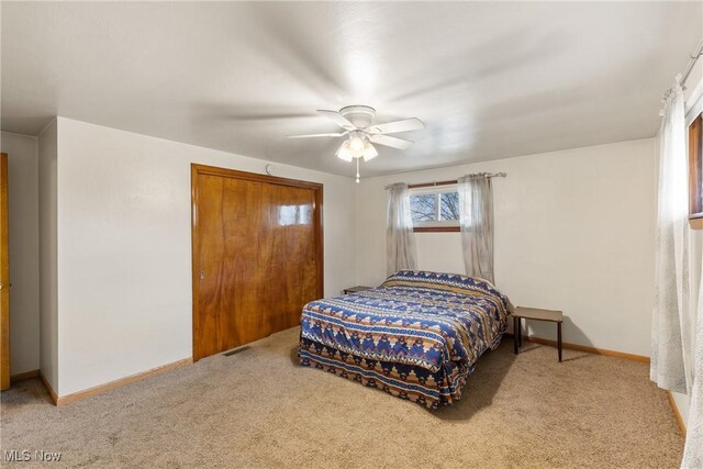 carpeted bedroom with a ceiling fan, visible vents, and baseboards