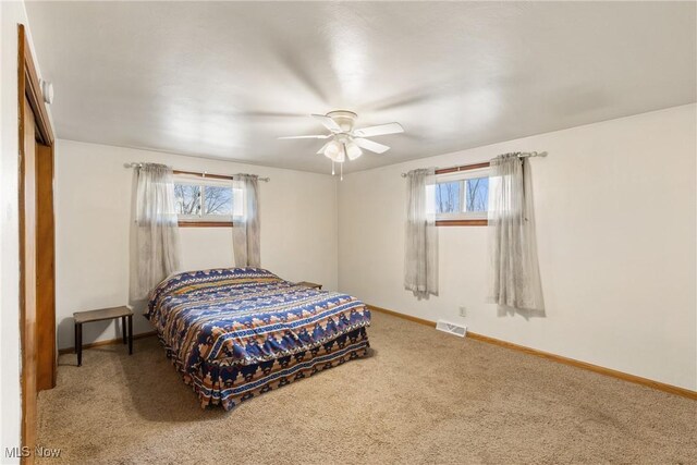 bedroom featuring baseboards, visible vents, multiple windows, and carpet flooring
