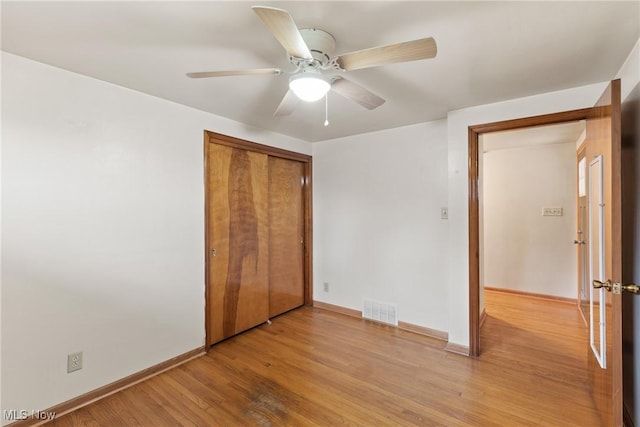 unfurnished bedroom with baseboards, visible vents, a closet, and light wood-style flooring