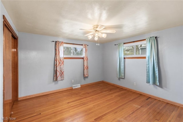unfurnished room with visible vents, ceiling fan, light wood-style floors, and a healthy amount of sunlight