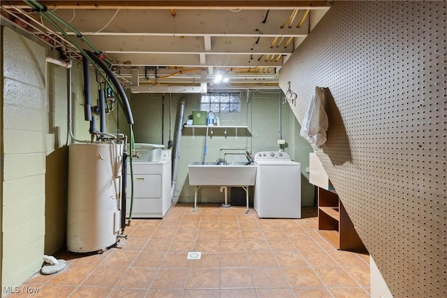 laundry area featuring independent washer and dryer, a sink, laundry area, water heater, and tile patterned flooring