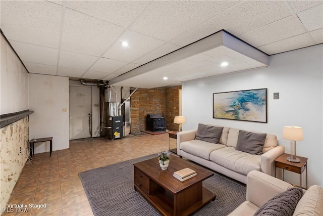 living room with a wood stove, a paneled ceiling, heating unit, and recessed lighting