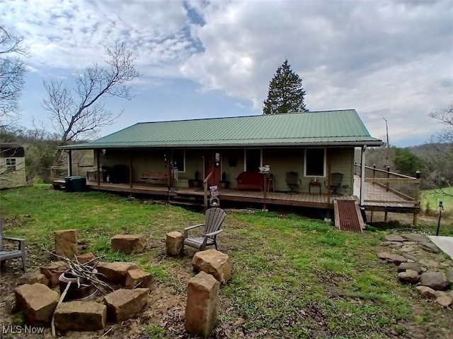 25977 E Hornsby Rd, Coolville, OH 45723 - back of house featuring an outdoor fire pit, metal roof, a porch, and a lawn