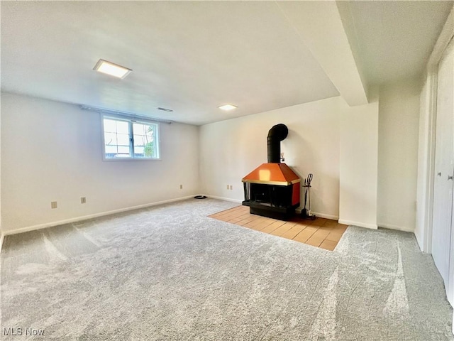 218 W Blvd, Mingo Junction, OH 43938 - unfurnished living room featuring carpet floors, baseboards, visible vents, and a wood stove