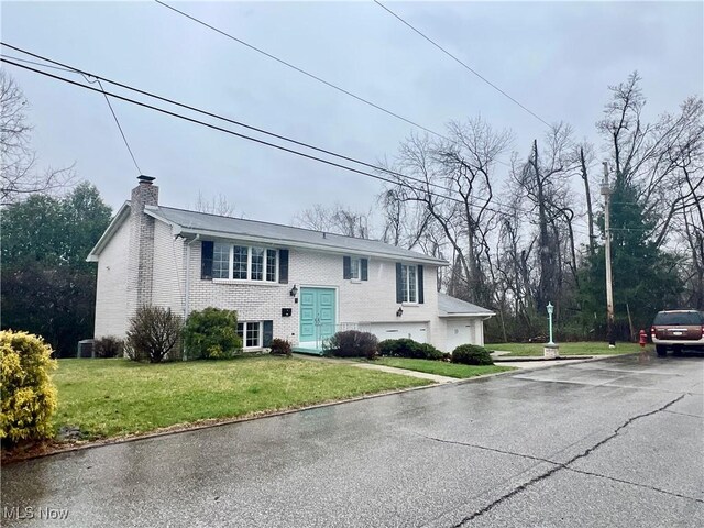 218 W Blvd, Mingo Junction, OH 43938 - bi-level home with brick siding, driveway, a front lawn, and a chimney