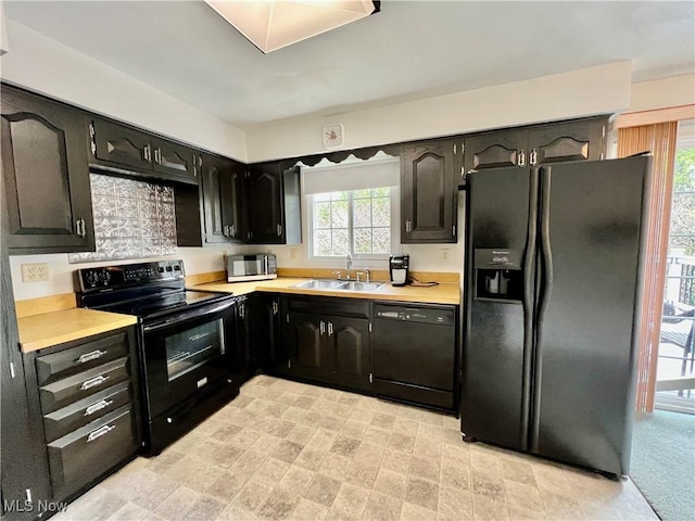 218 W Blvd, Mingo Junction, OH 43938 - kitchen featuring light countertops, a sink, dark cabinetry, and black appliances