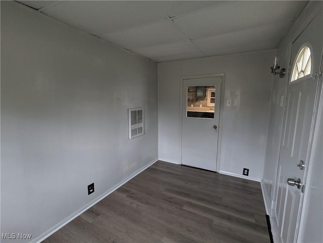 spare room with baseboards, visible vents, a paneled ceiling, and dark wood-style flooring