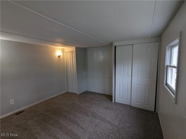 unfurnished bedroom with a closet, carpet floors, and visible vents