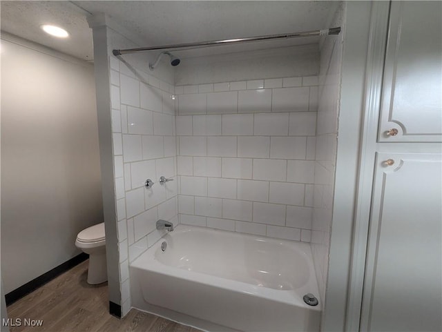 bathroom featuring toilet, shower / tub combination, baseboards, and wood finished floors