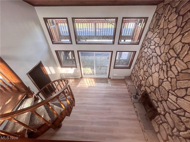 3013 Whispering Pines Dr, Canfield, OH 44406 - unfurnished living room featuring baseboard heating, wood finished floors, and a towering ceiling