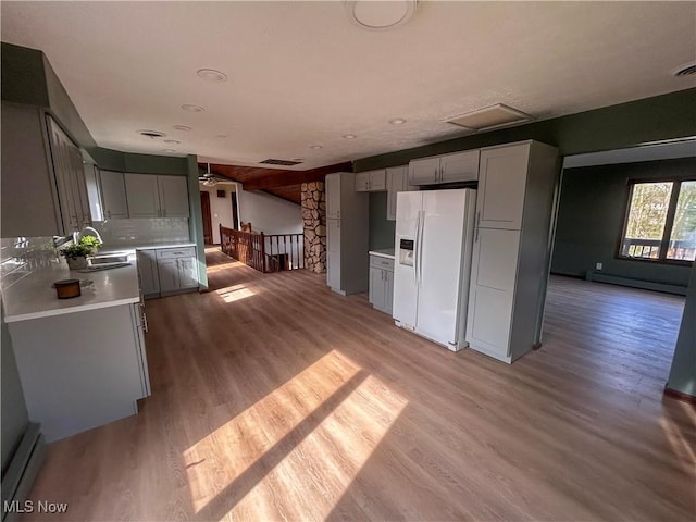 3013 Whispering Pines Dr, Canfield, OH 44406 - kitchen featuring a baseboard heating unit, visible vents, light wood finished floors, and white fridge with ice dispenser