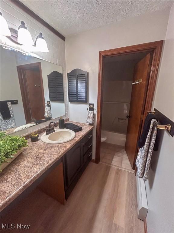 3013 Whispering Pines Dr, Canfield, OH 44406 - bathroom with vanity, a textured ceiling, toilet, and wood finished floors