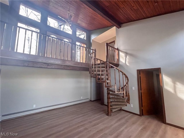 3013 Whispering Pines Dr, Canfield, OH 44406 - stairway featuring baseboard heating, wood finished floors, wooden ceiling, a high ceiling, and a wealth of natural light