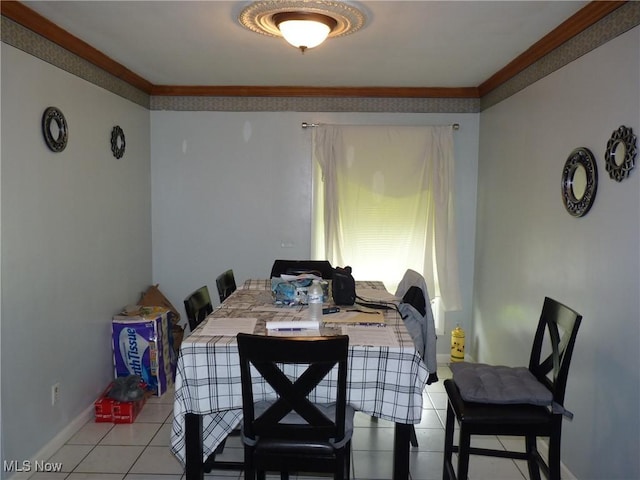 dining area featuring light tile patterned floors, ornamental molding, and baseboards