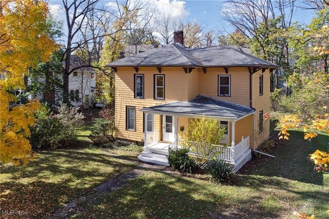 34 N Park St, Oberlin, OH 44074 - view of front of house with a chimney, a porch, a front lawn, and roof with shingles