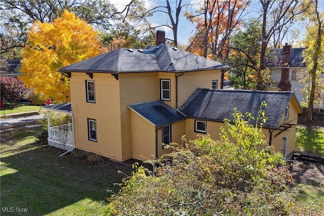 34 N Park St, Oberlin, OH 44074 - back of property with a chimney, roof with shingles, and a lawn