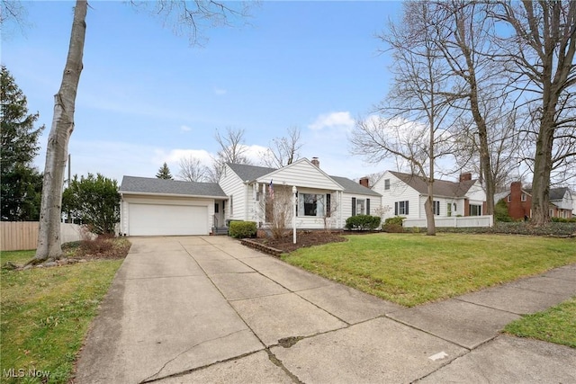 view of front of home with a front lawn, fence, an attached garage, and concrete driveway