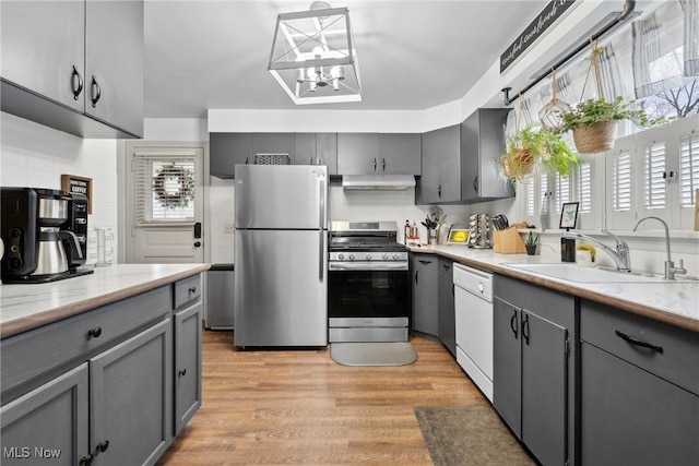 kitchen featuring gray cabinetry, a sink, and stainless steel appliances