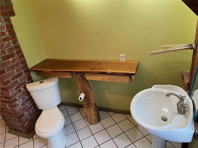 6232 Weaver Rd, Conneaut, OH 44030 - half bath with tile patterned floors, toilet, baseboards, and a sink