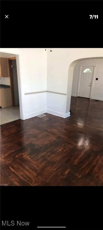 spare room featuring arched walkways
