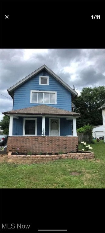view of front facade featuring brick siding and a front lawn