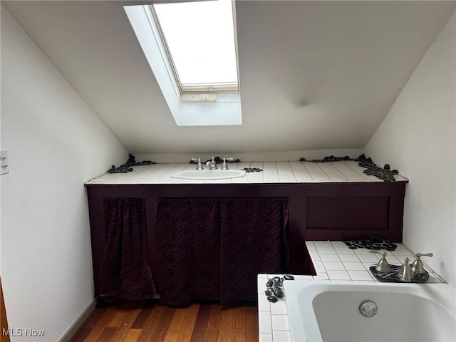 6232 Weaver Rd, Conneaut, OH 44030 - bathroom with wood finished floors, a skylight, a bathing tub, and a sink
