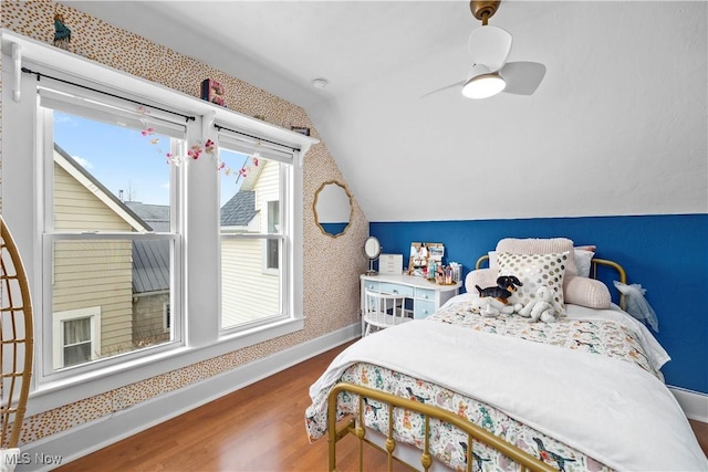 bedroom with baseboards, vaulted ceiling, and wood finished floors