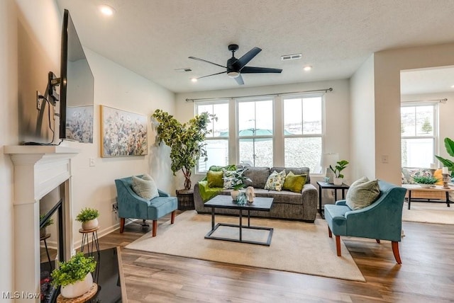 855-2 Dipper Ln, Aurora, OH 44202 - living area with a ceiling fan, wood finished floors, a glass covered fireplace, recessed lighting, and a textured ceiling