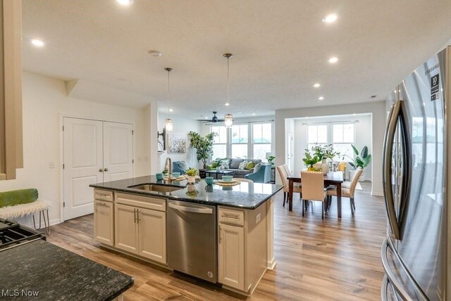 855-2 Dipper Ln, Aurora, OH 44202 - kitchen with stainless steel appliances, open floor plan, a kitchen island with sink, dark stone counters, and recessed lighting