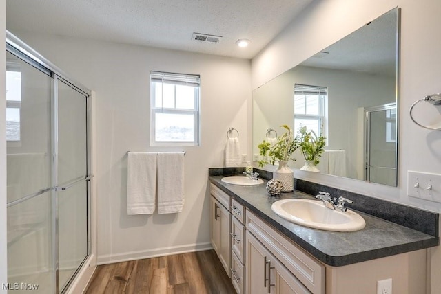 855-2 Dipper Ln, Aurora, OH 44202 - full bathroom with double vanity, a stall shower, wood finished floors, plenty of natural light, and a textured ceiling