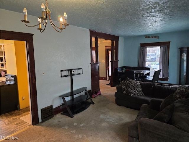 38 Royal Pl, Akron, OH 44310 - carpeted living room with a textured ceiling, visible vents, a chandelier, and washer / dryer
