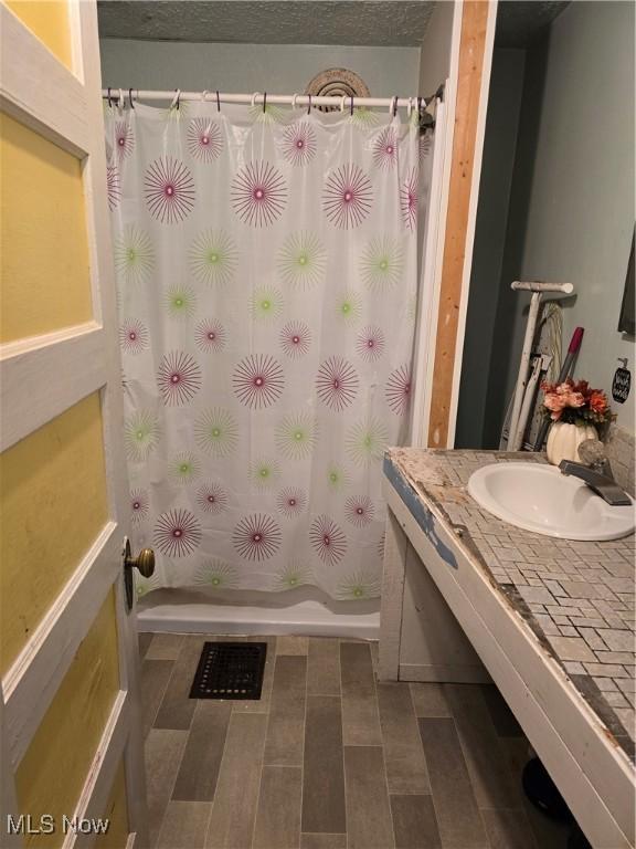 38 Royal Pl, Akron, OH 44310 - bathroom with vanity, a textured ceiling, and curtained shower