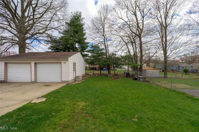 view of yard with an outdoor structure, a detached garage, and fence