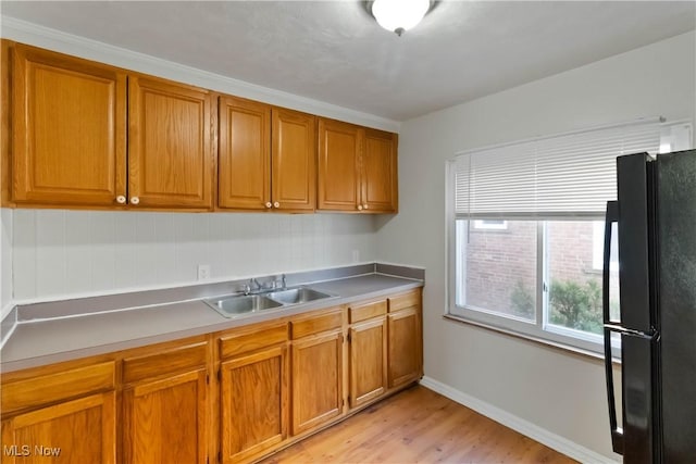 17809 Harvard Ave, Cleveland, OH 44128 - kitchen featuring brown cabinetry, a sink, and freestanding refrigerator