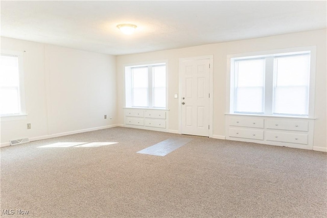 unfurnished room featuring carpet, baseboards, and visible vents