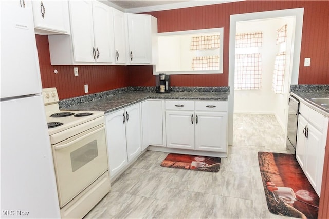 kitchen featuring white cabinetry, a sink, dark countertops, and white appliances