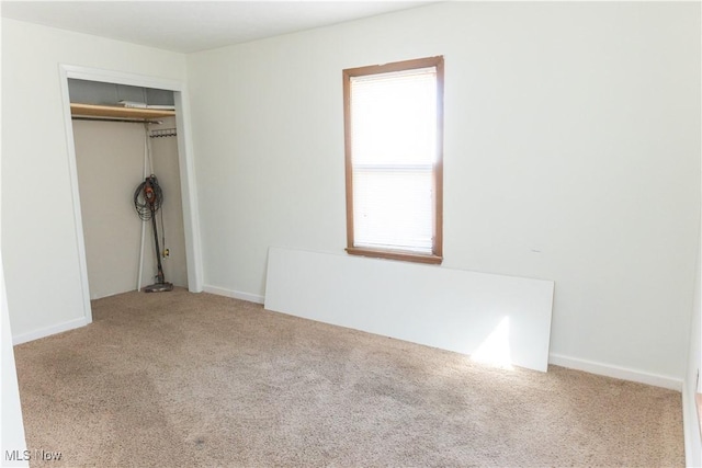 unfurnished bedroom featuring carpet and a closet
