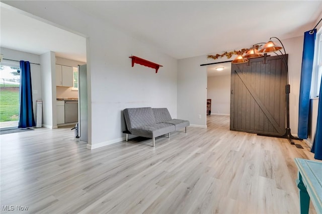 44 Hickory Dr, Little Hocking, OH 45742 - unfurnished room featuring baseboards, a barn door, and light wood-type flooring
