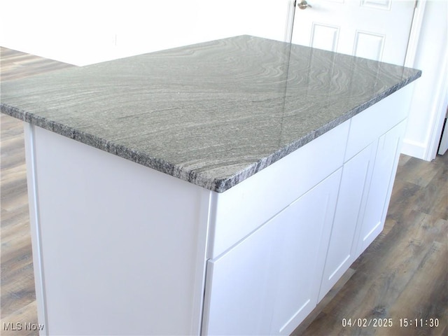 exterior details featuring white cabinetry and dark stone countertops