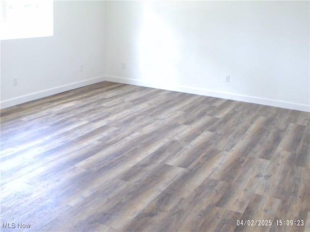 empty room featuring baseboards and wood finished floors