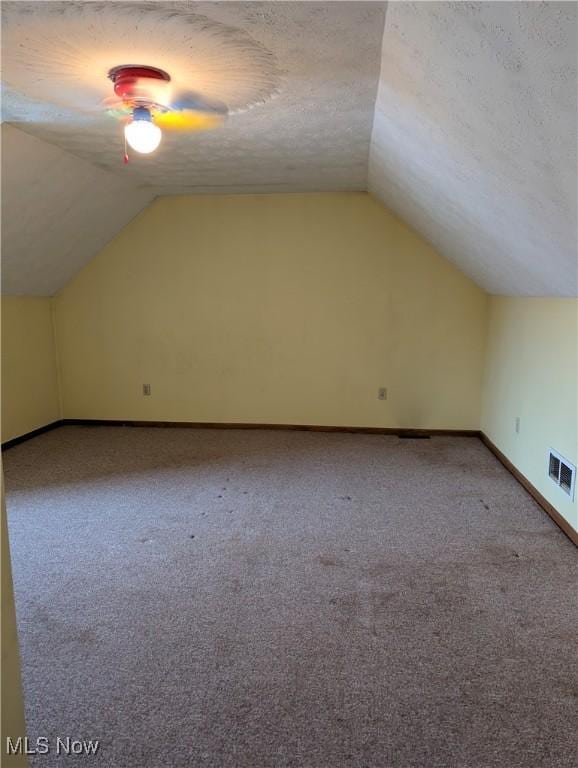 44790 County Road 23, Coshocton, OH 43812 - additional living space featuring a textured ceiling, baseboards, vaulted ceiling, and visible vents
