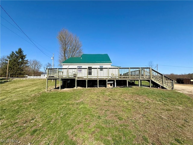 rear view of house with metal roof, fence, and a yard