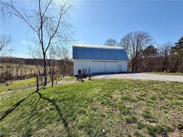 view of pole building with fence and a lawn