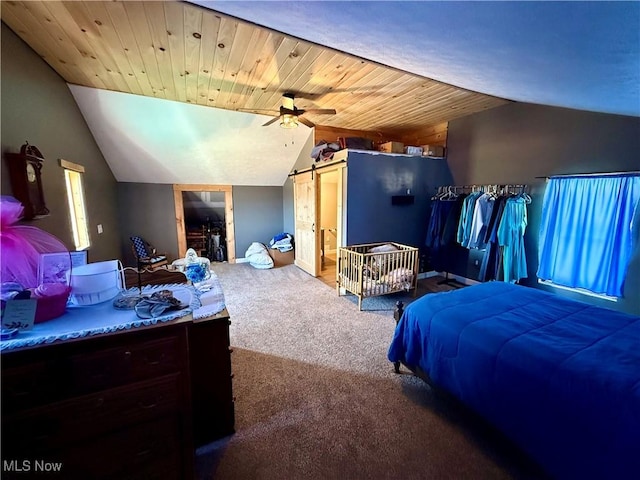 bedroom with carpet flooring, wooden ceiling, a barn door, and vaulted ceiling