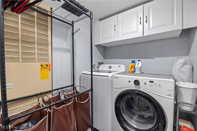 laundry area with washing machine and dryer, cabinet space, and a heating unit