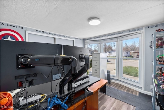 office area featuring baseboards, a textured ceiling, and wood finished floors