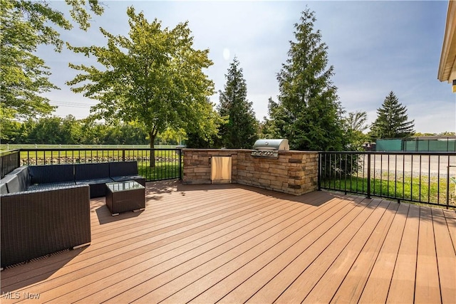 wooden terrace with an outdoor hangout area, an outdoor kitchen, and area for grilling